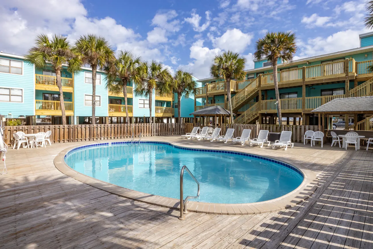 Pool with teal-painted Lani Kai building and palm trees