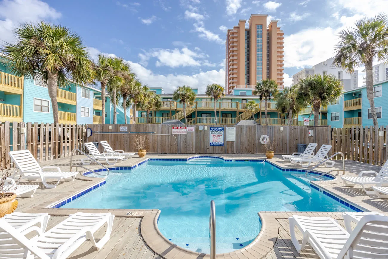 Family pool with attached spa, high-rise condo in background