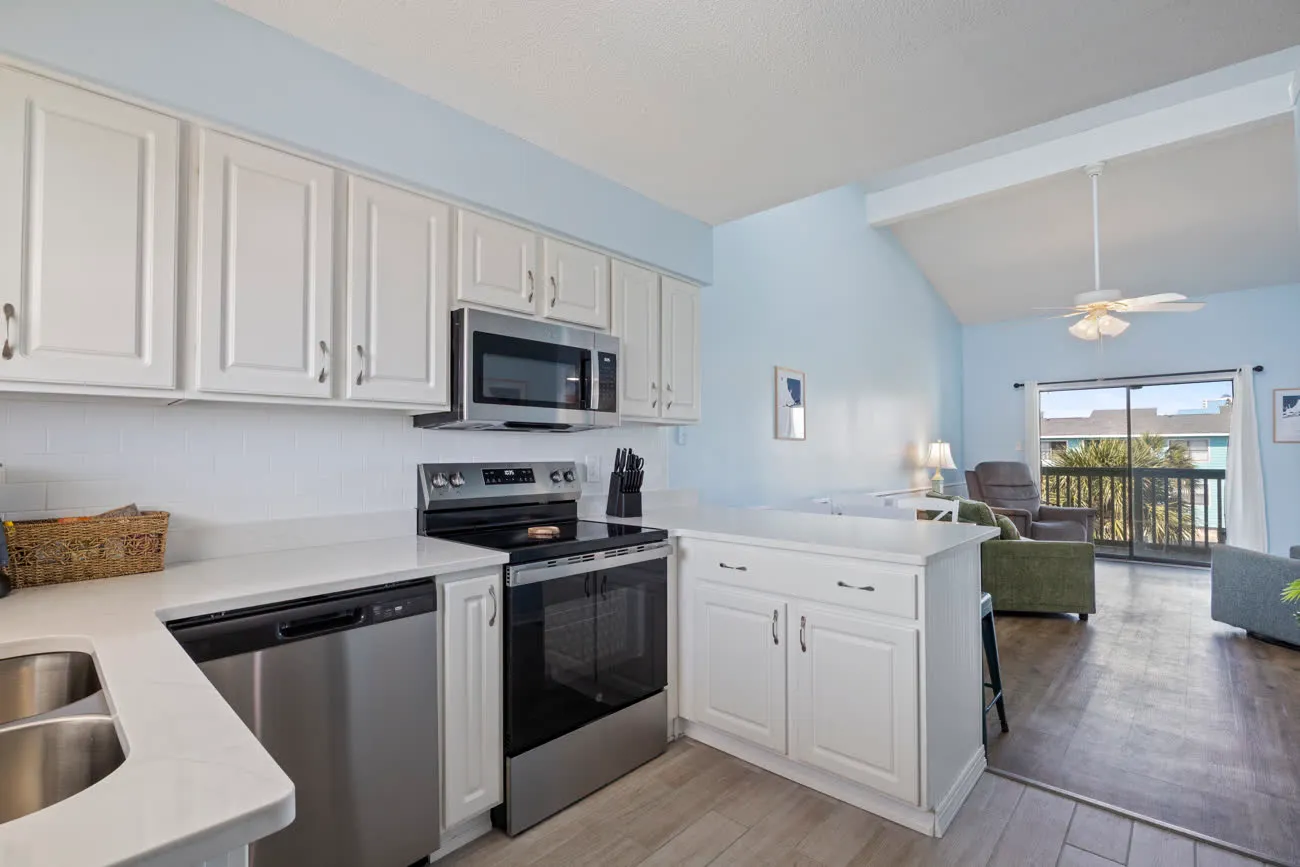 Renovated kitchen with stainless appliances and view through to living room