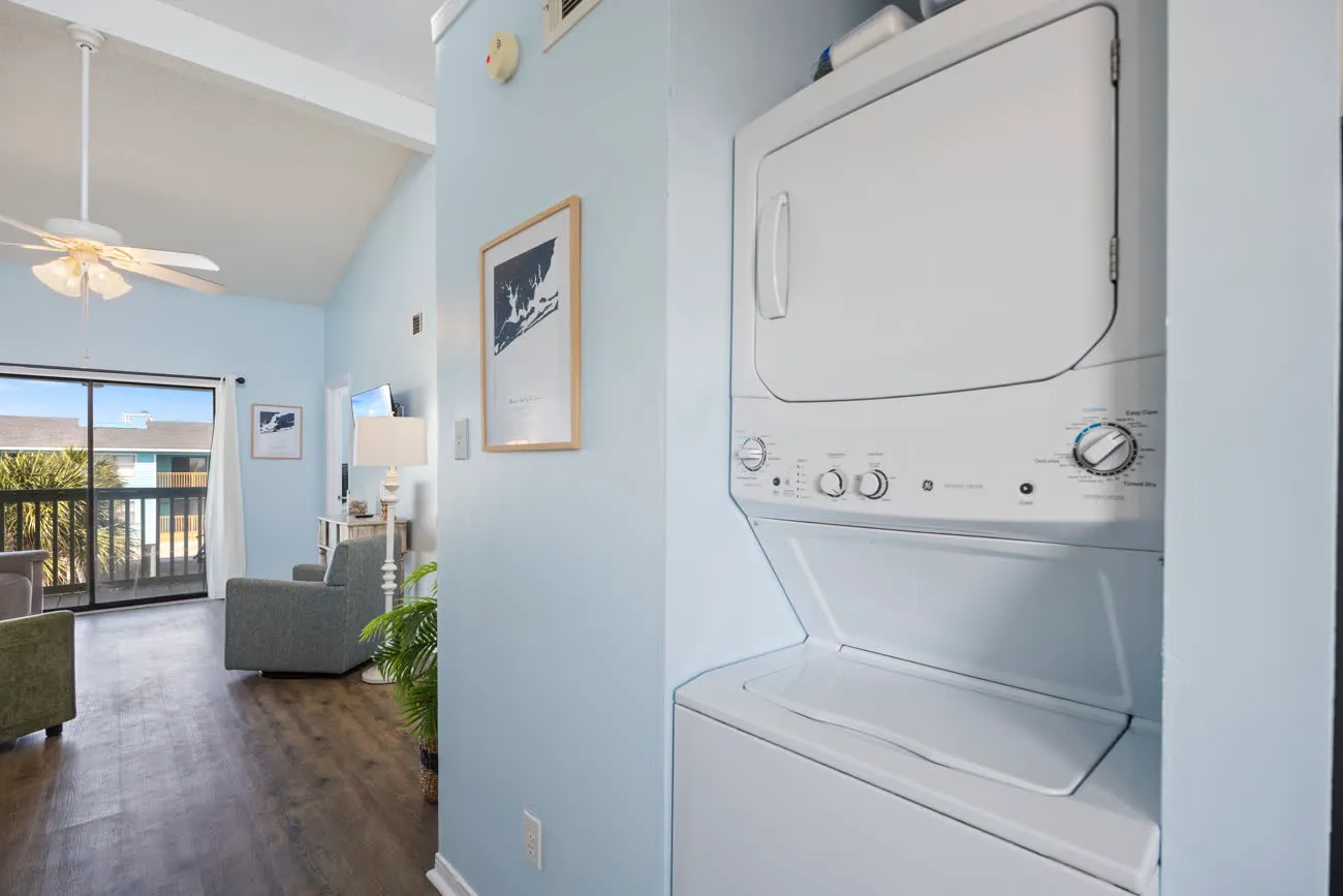 Living room visible past the in-unit washer and dryer