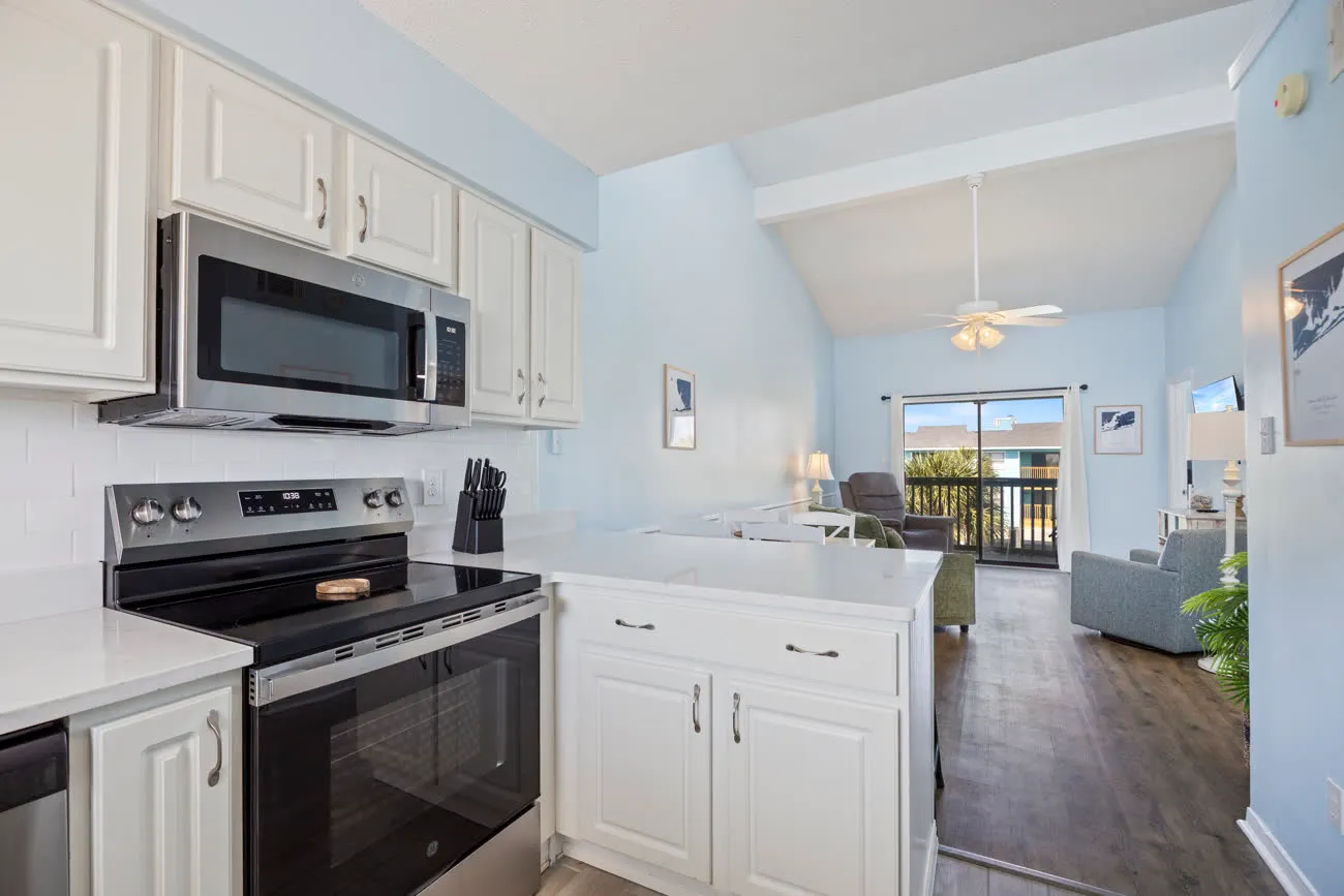 Kitchen with stove and microwave, looking into the living area