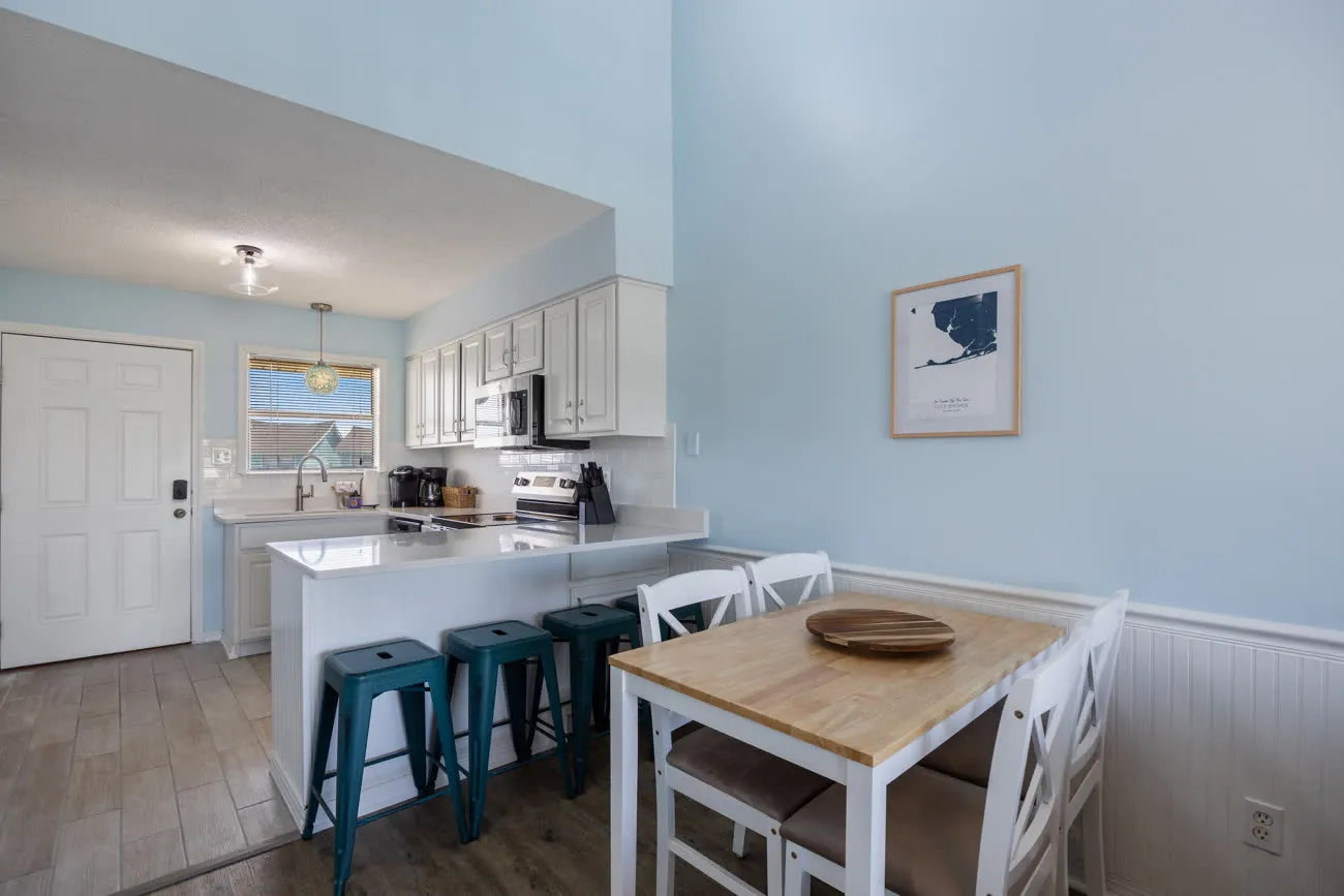 Kitchen breakfast bar with three stools and dining table