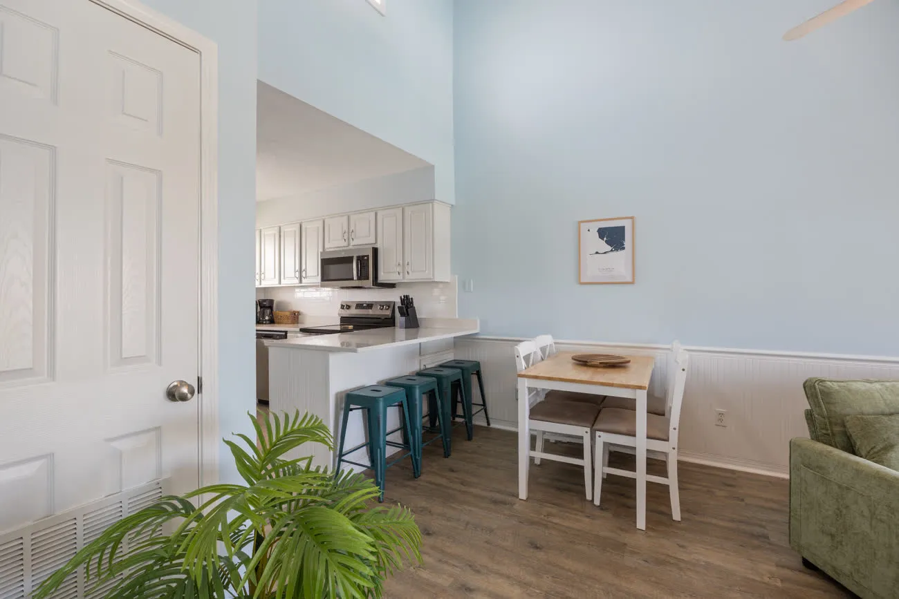 Open kitchen with bar stools and dining table seen from doorway