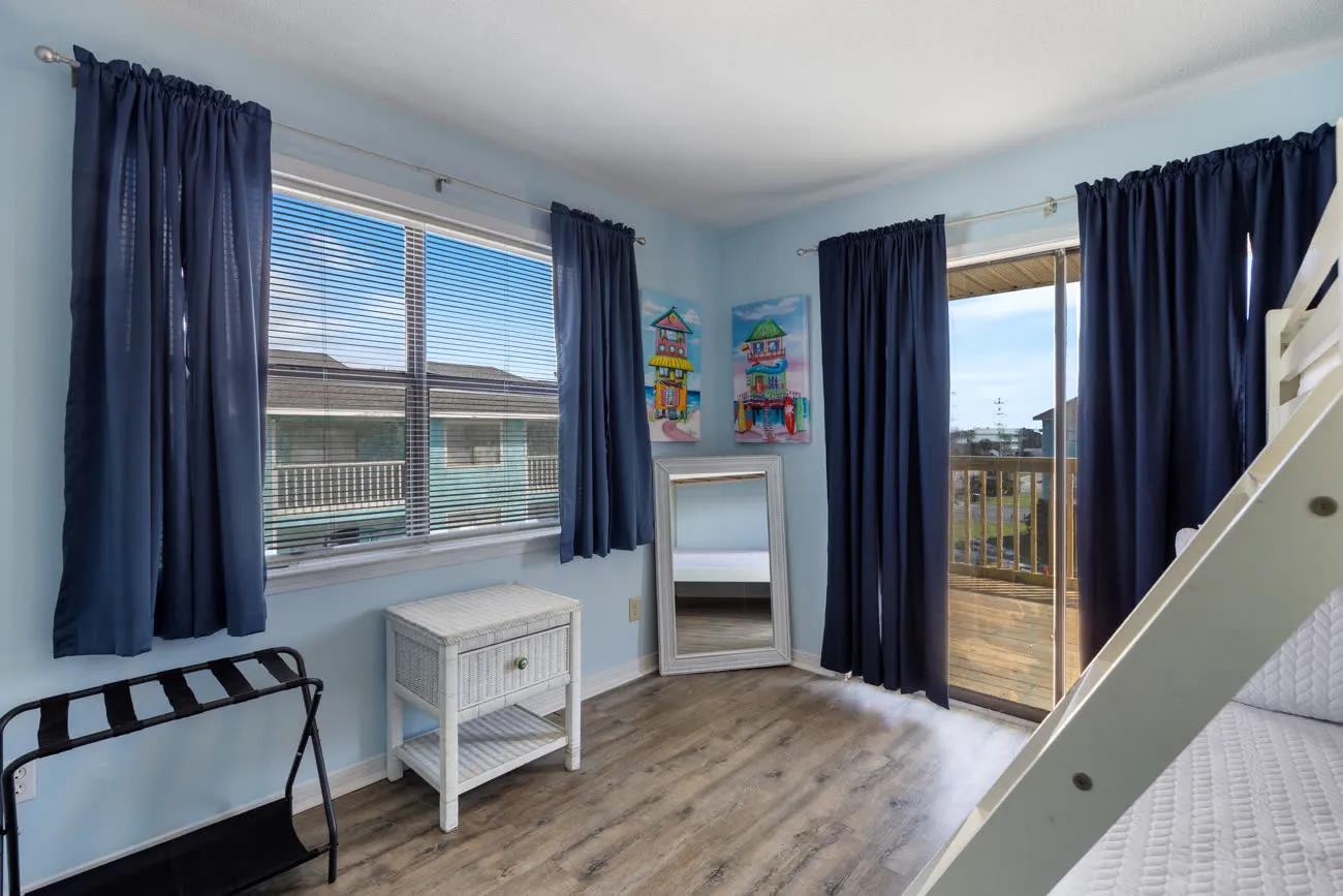 Second bedroom corner with windows and partial bunk bed