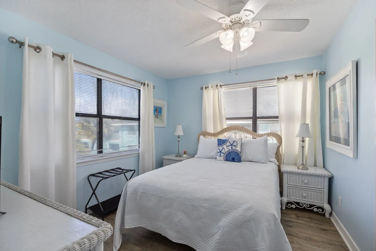 Master bedroom with queen bed, white linens, and ceiling fan