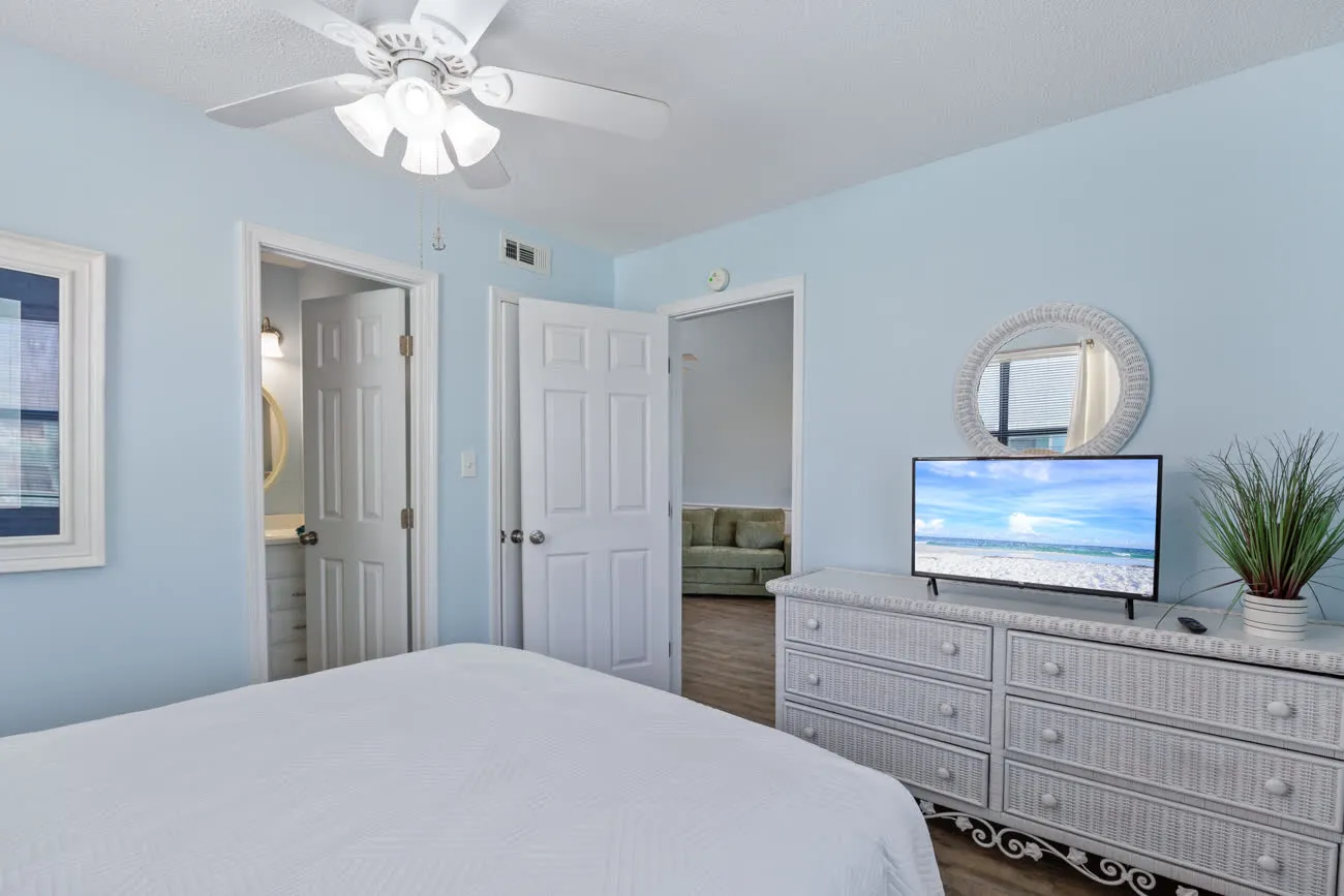 Master bedroom dresser and TV with view into en-suite bathroom