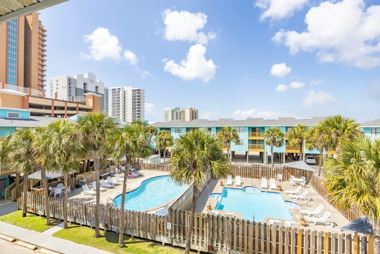 Both pools from balcony with palms and high-rise behind